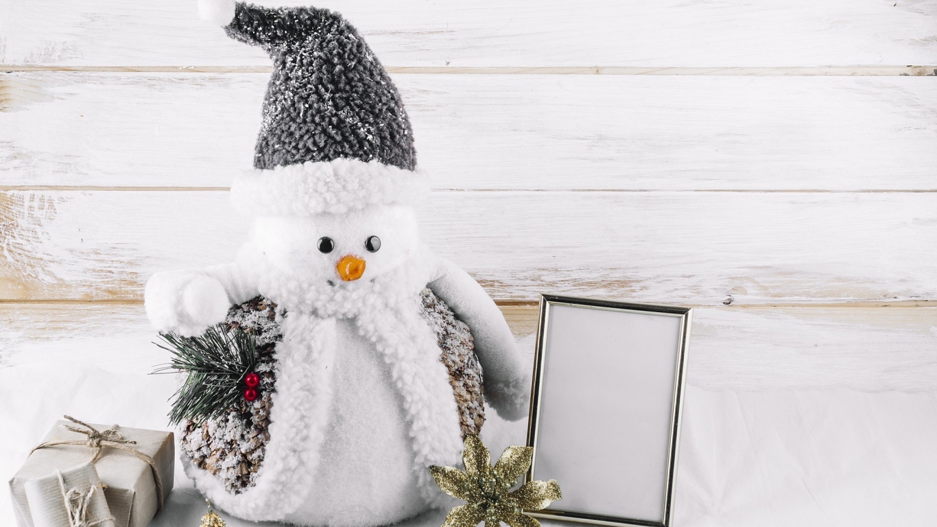 Большой игрушечный снеговик на деревянном фоне