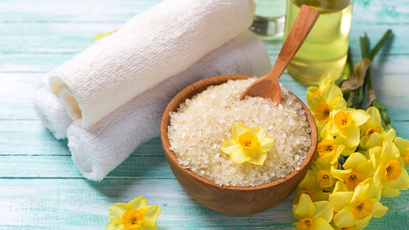Соль с цветами нарцисса и полотенцем на столе