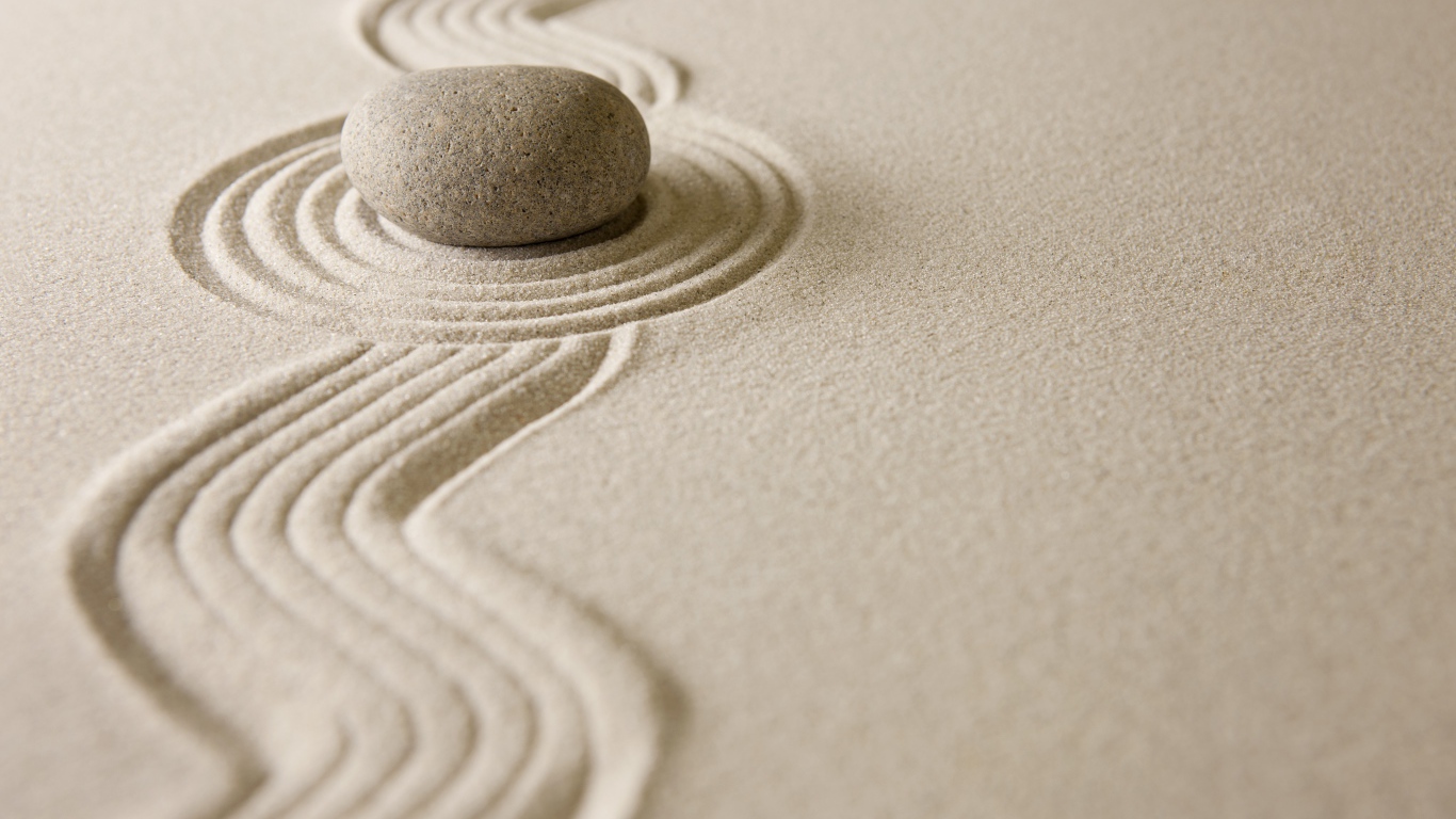 Камень лежит на рисунке на песке, дзен