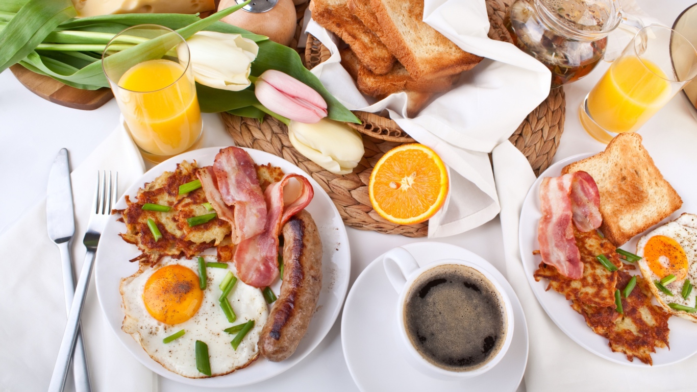 Сытный завтрак на столе с букетом тюльпанов 