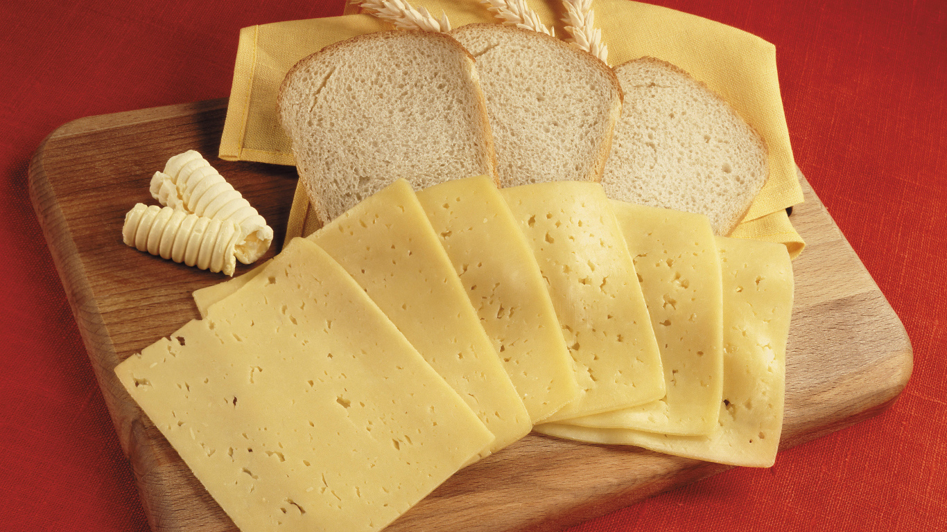 Хлеб с кусками сыра на разделочной доске