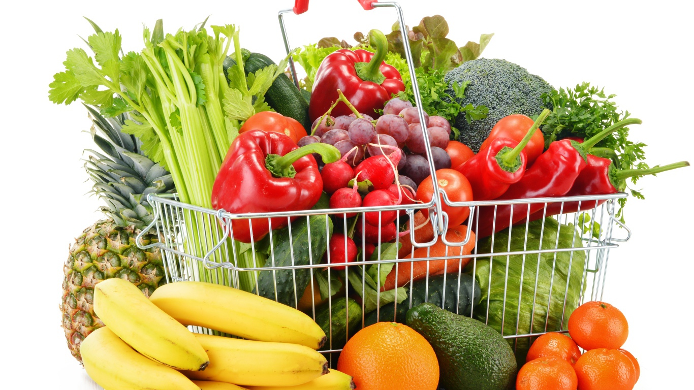 Железная корзина со свежими овощами и фруктами на белом фоне