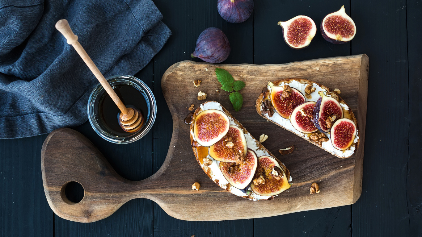 Бутерброды с инжиром на разделочной доске с медом 