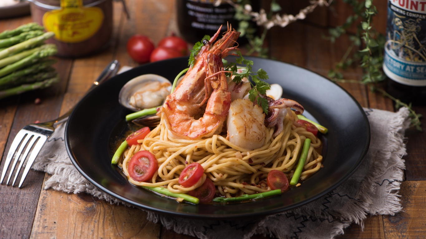 Спагетти с морепродуктами на черной тарелке