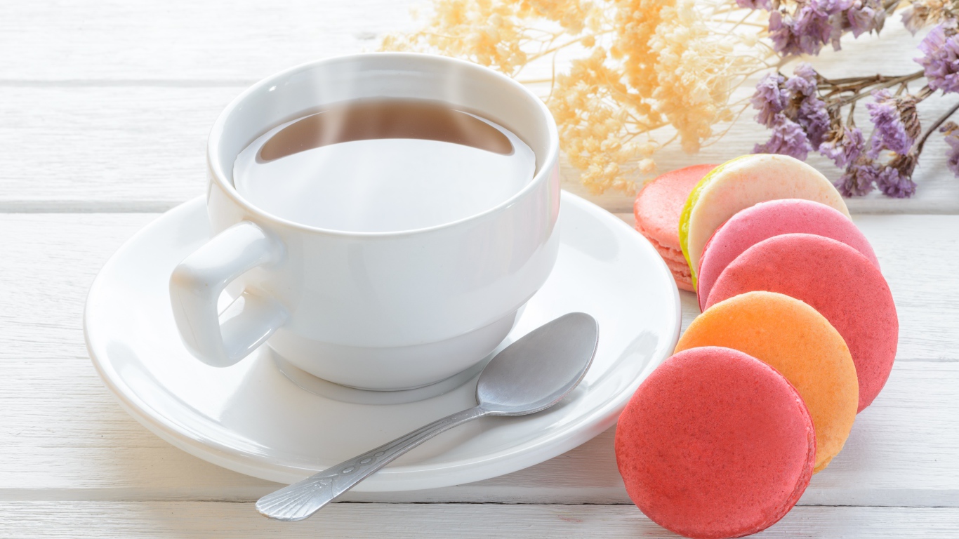 Белая чашка чая с макарунами