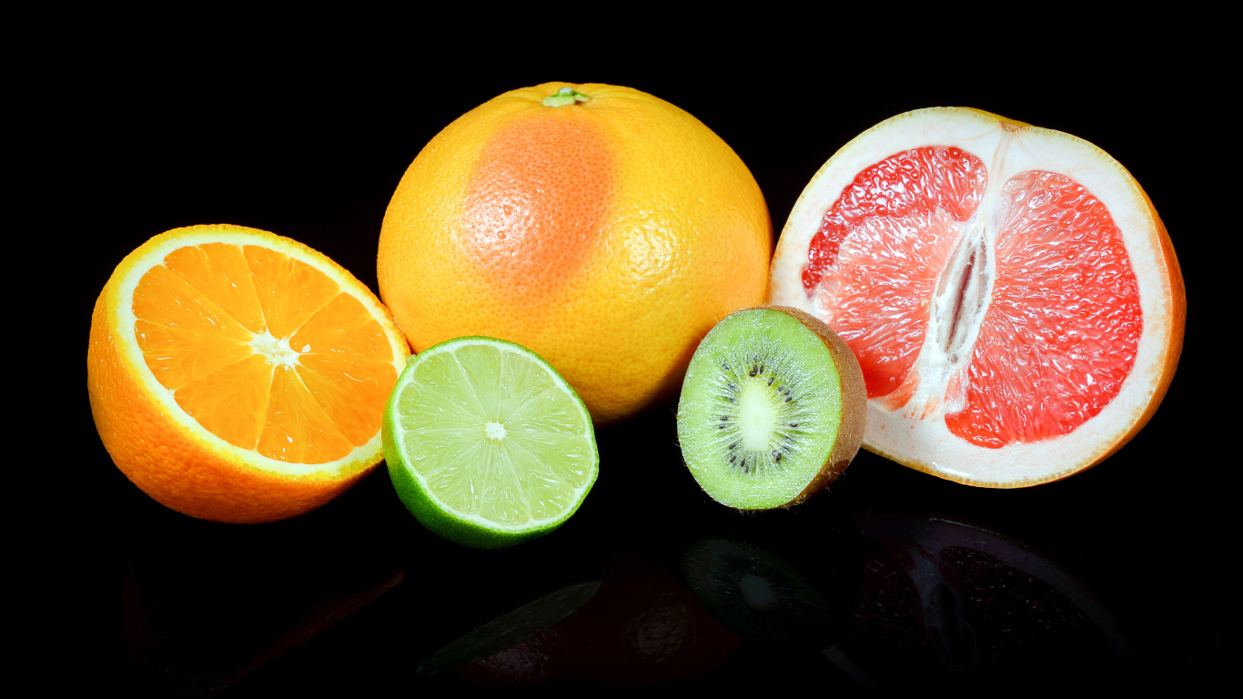 Апельсины, грейпфруты,  лайм и киви на черном фоне