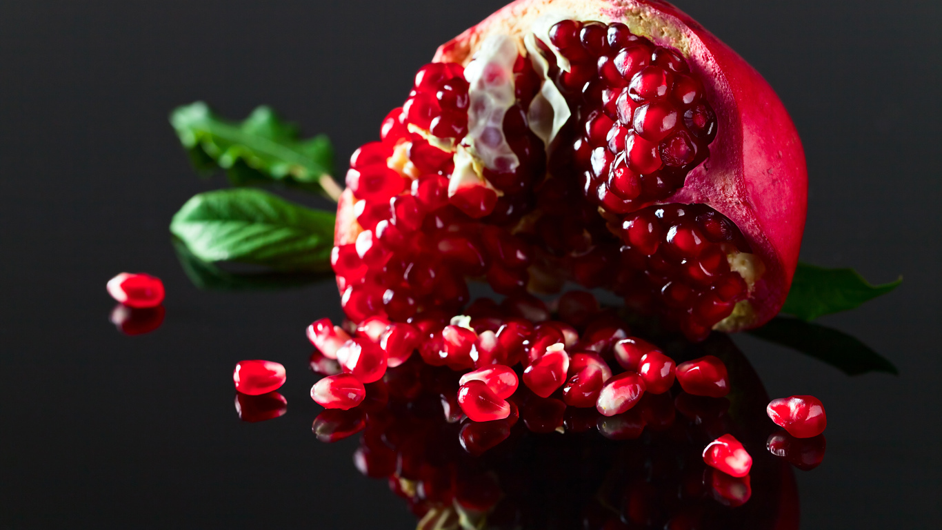 Чищенный гранат на сером фоне крупным планом