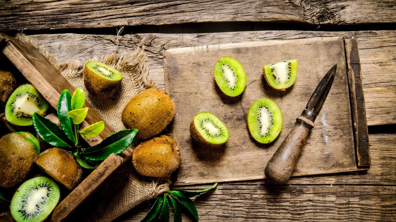 Нарезанное киви на разделочной доске с ножом