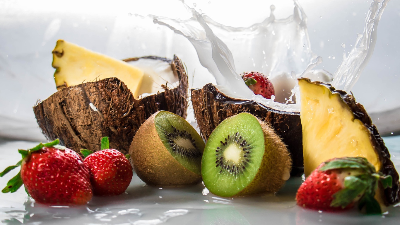 Тропические фрукты кокосы, ананасы и киви на белом фоне с клубникой