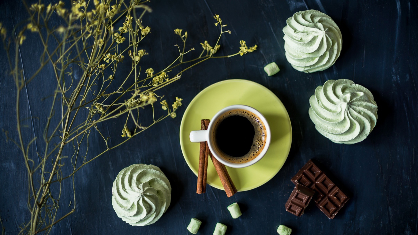 Чашка кофе с меренгой и шоколадом на столе