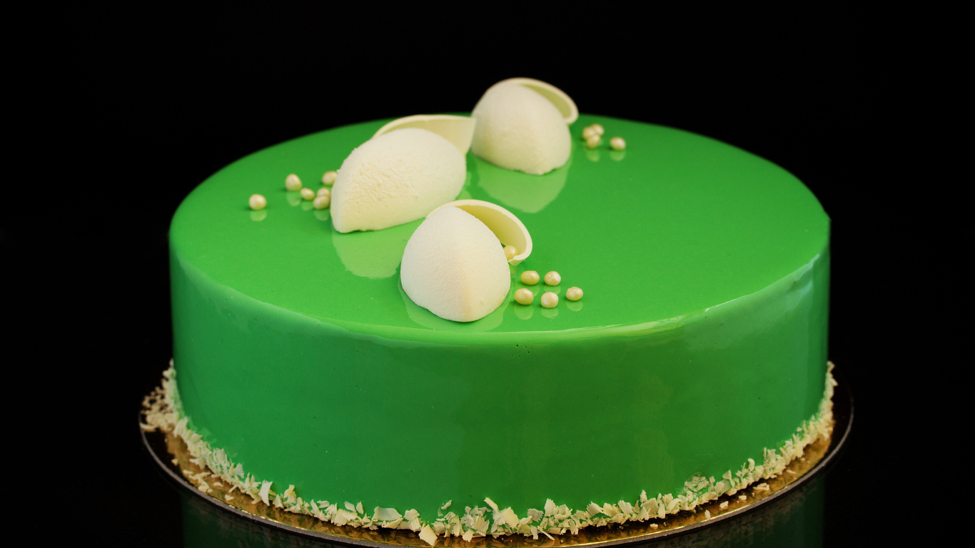 Зеленый глянцевый торт отражается в черной поверхности 