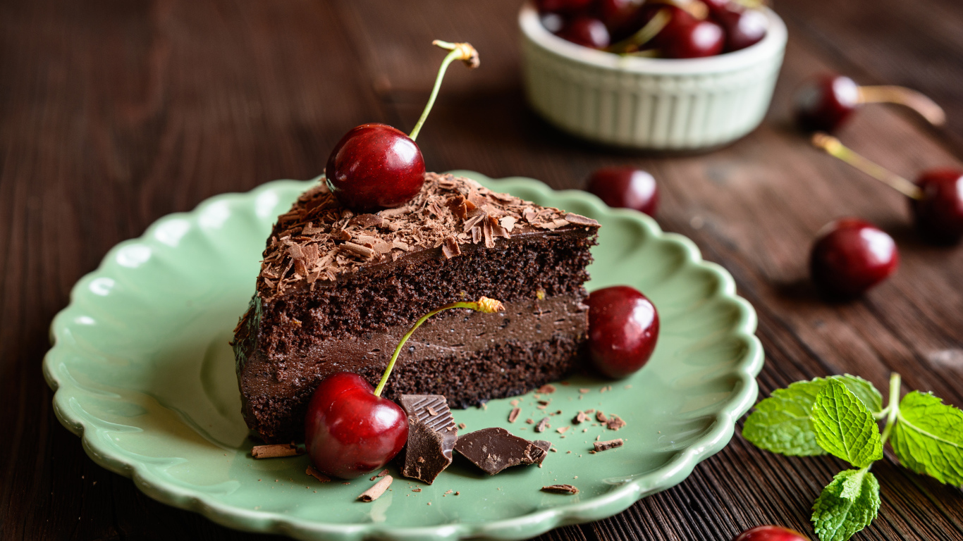 Кусок пирожного с черешнями на тарелке