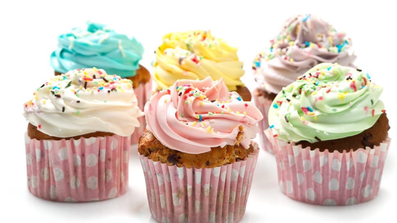 Аппетитные капкейки с кремом на белом фоне