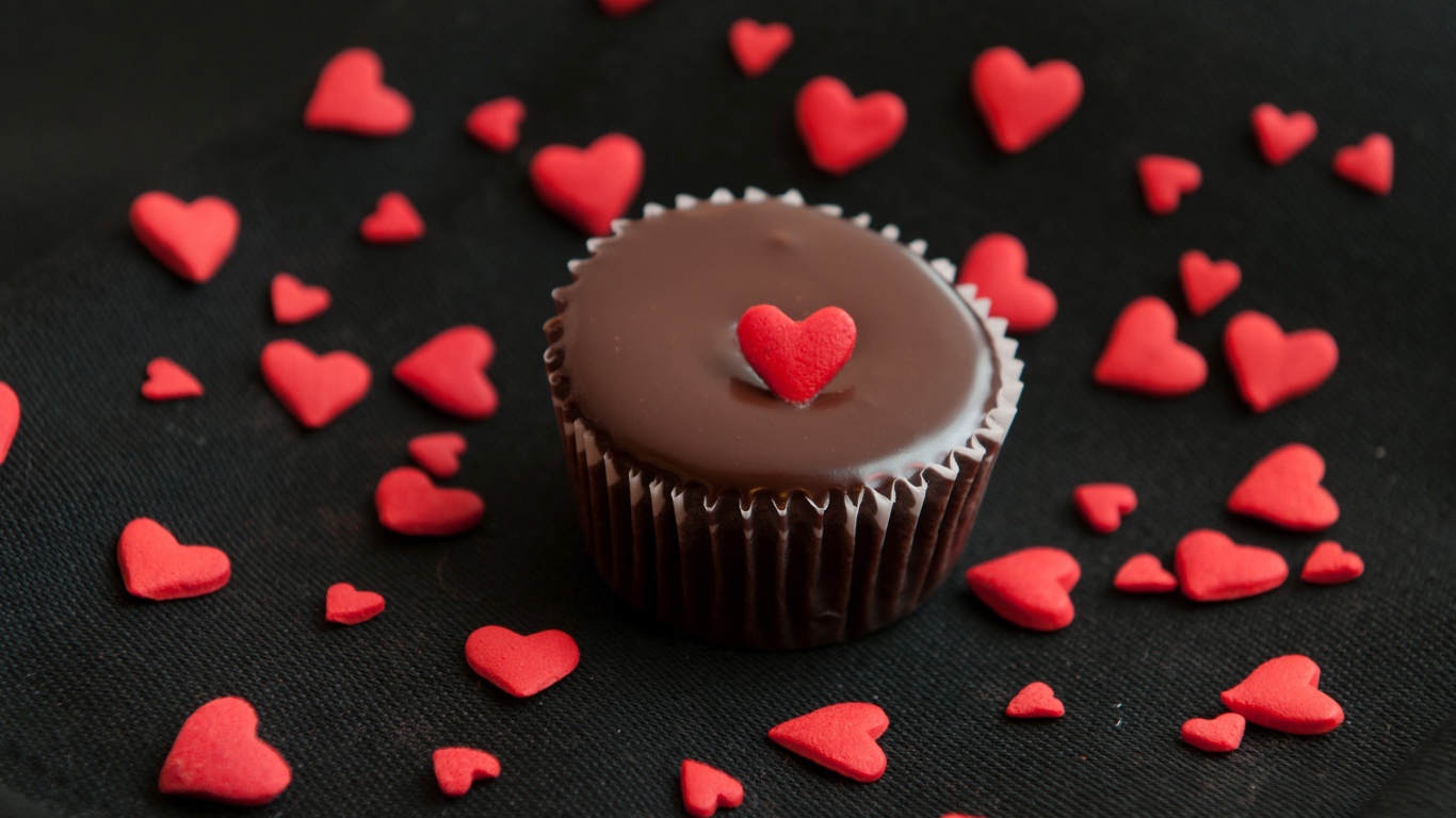 Аппетитный шоколадный кекс украшен маленькими сердечками