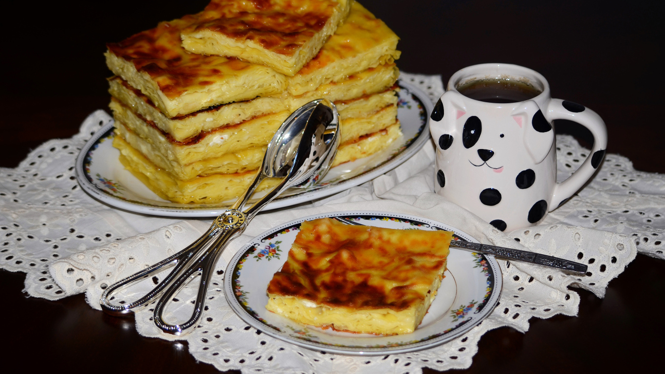 Аппетитный сладкий пирог с чашкой чая на столе