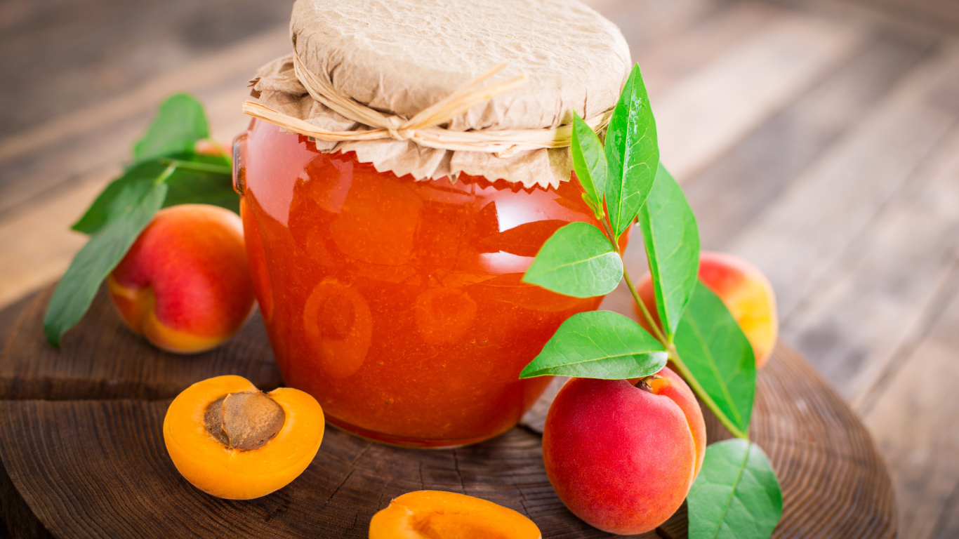Абрикосовое варенье в банке на столе с абрикосами