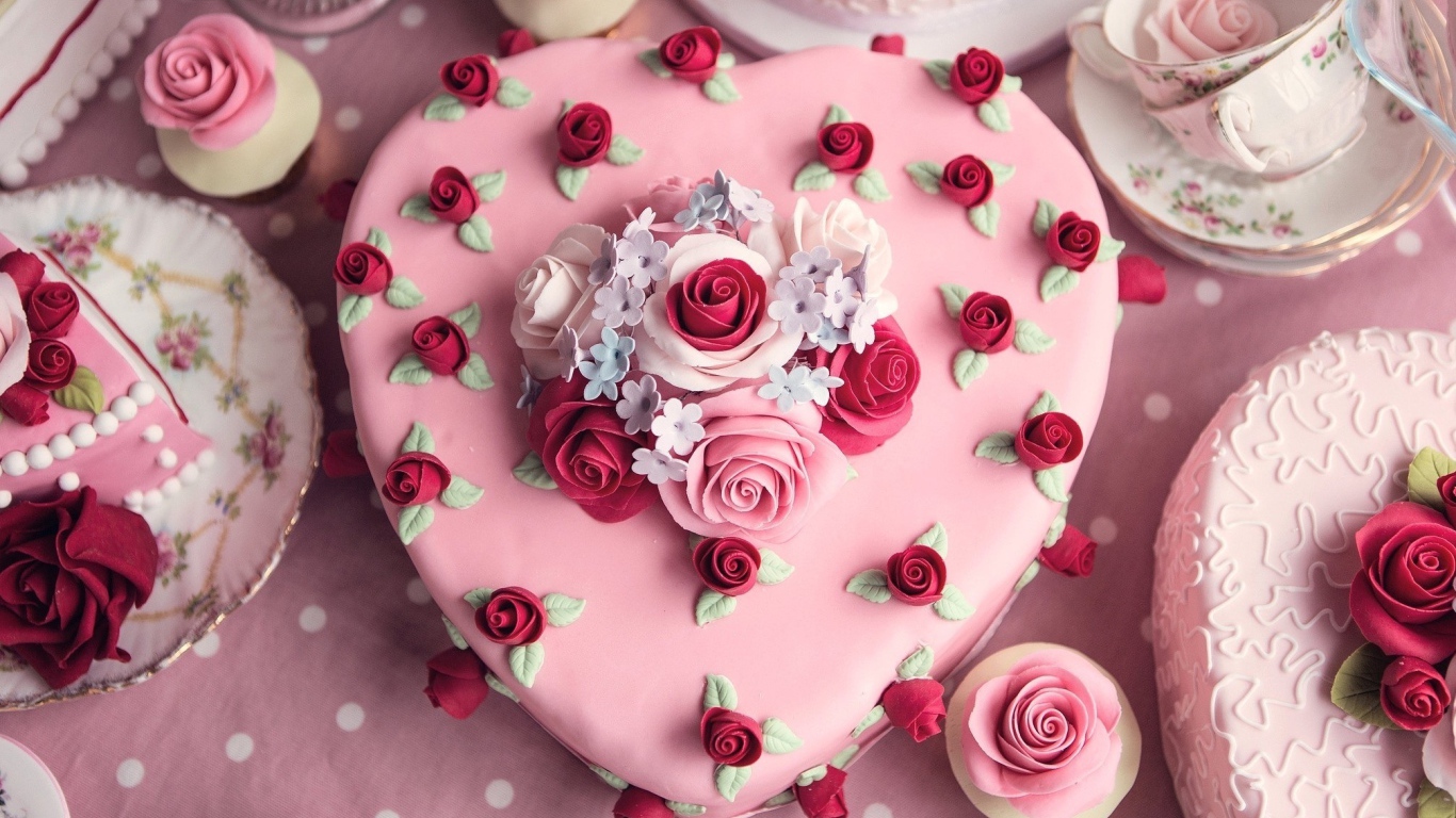 Красивый праздничный розовый торт в форме сердца украшен цветами