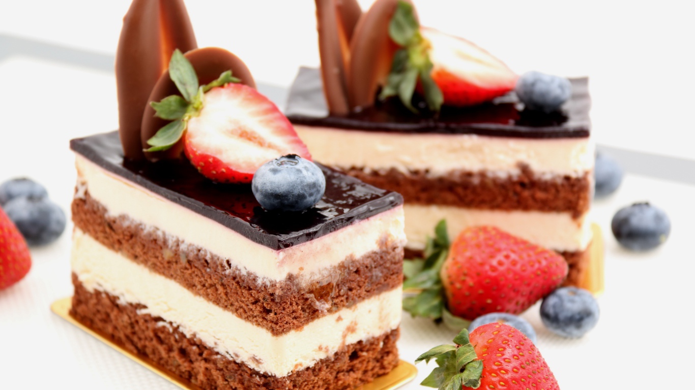 Пирожные с шоколадом, кремом и ягодами клубники и черники