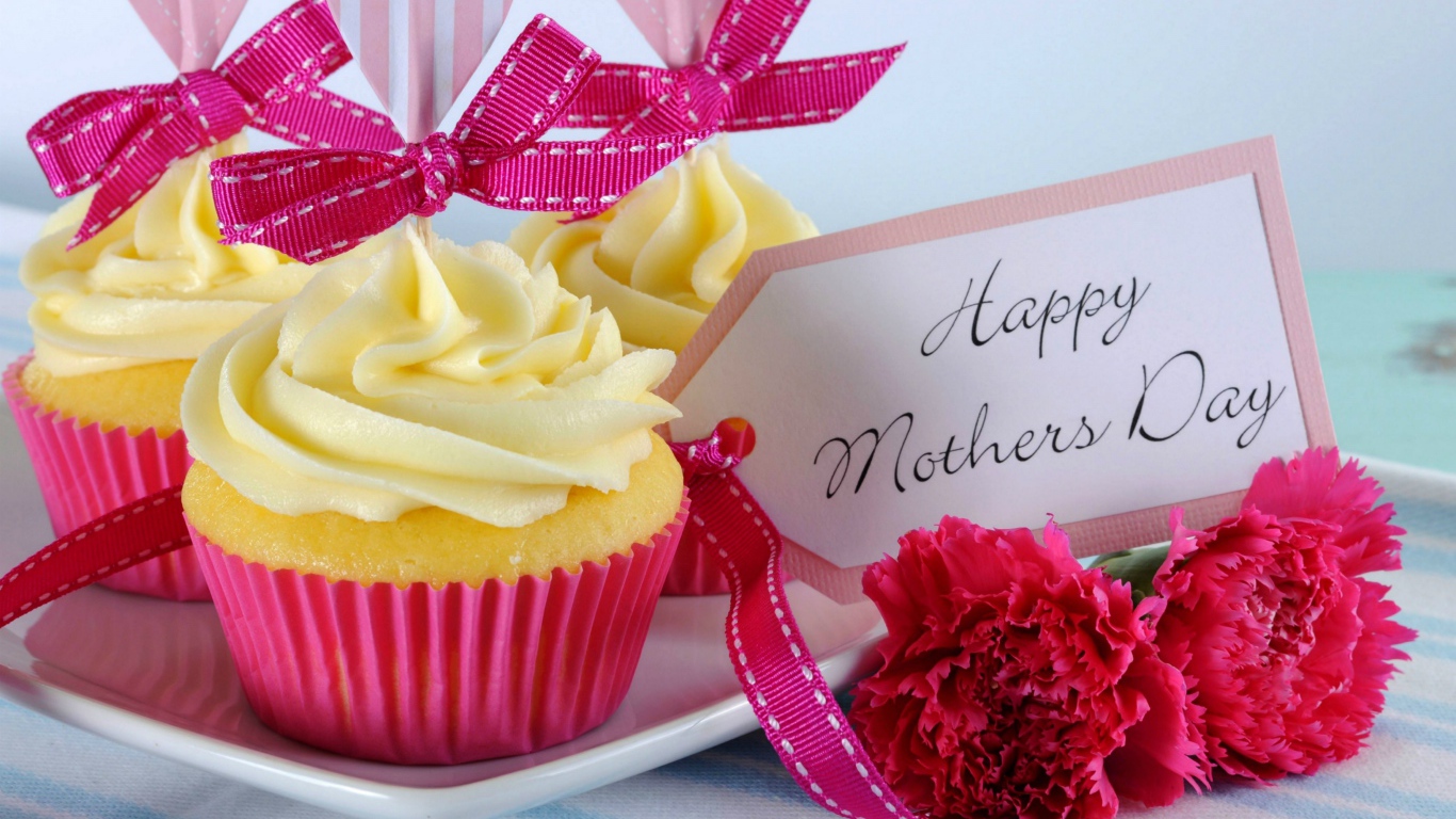 Кексы с кремом рядом с гвоздиками и пожеланиями к Дню матери