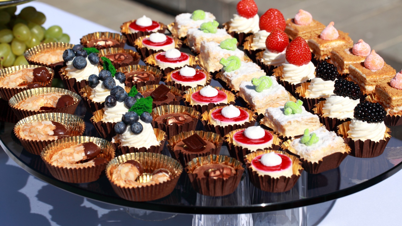 Много разных сладких десертов на столе