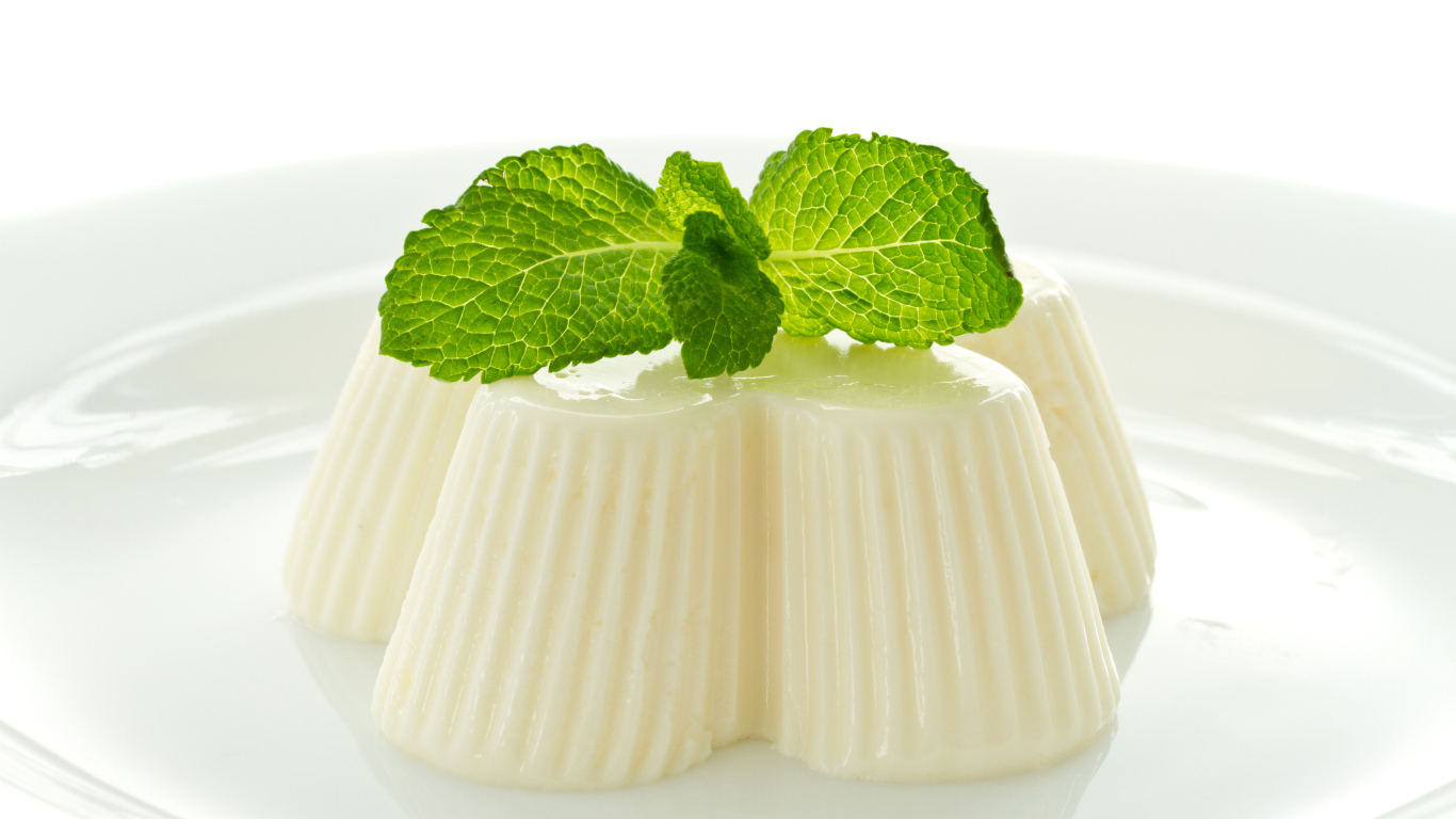 Молочное желе с мятой на белой тарелке 