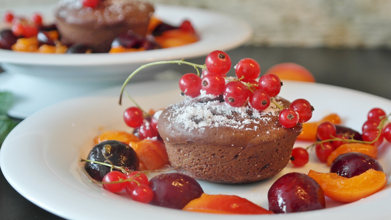 Кексы с красной смородиной на тарелке с ягодами 