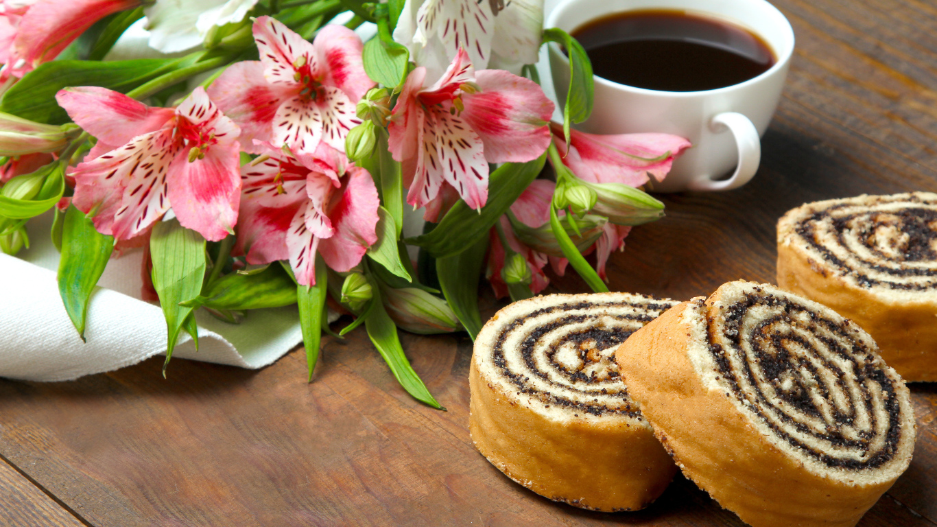 Рулет с маком на столе с цветами альстрёмерия и чашкой кофе