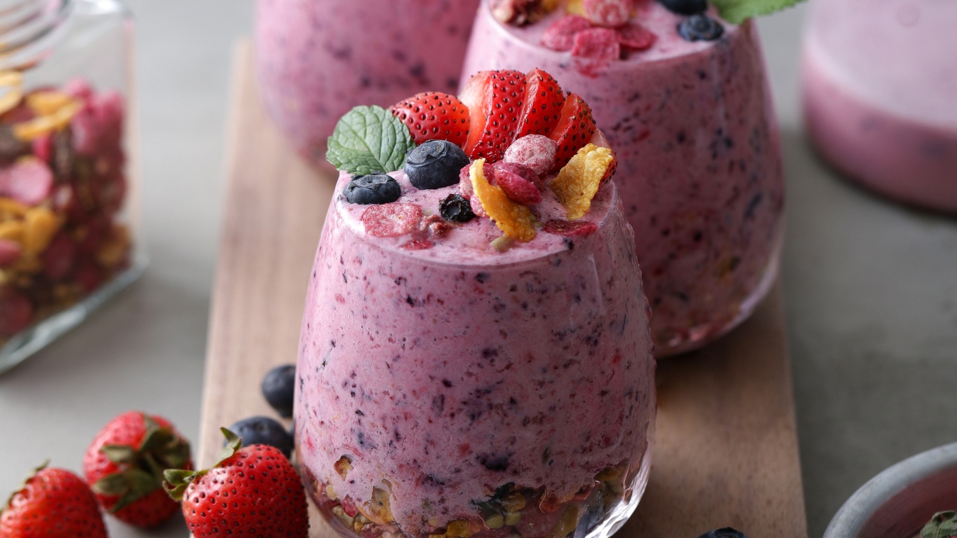 Сладкий десерт с ягодами в стаканах на столе