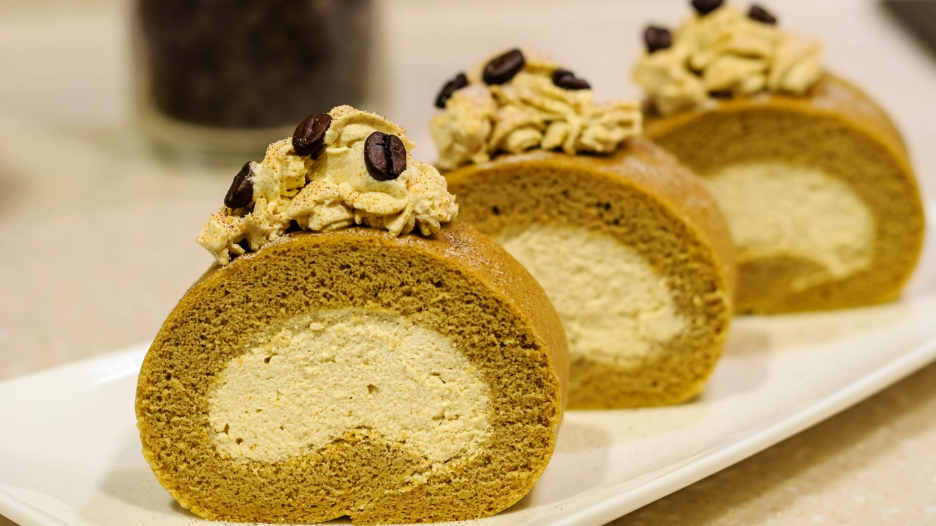 Сладкий рулет с кремом и зернами кофе