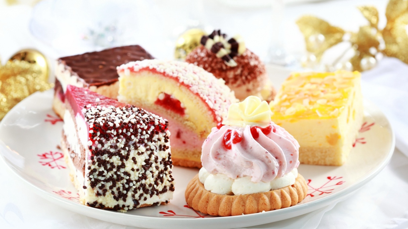 Сладкие вкусные разные пирожные на тарелке