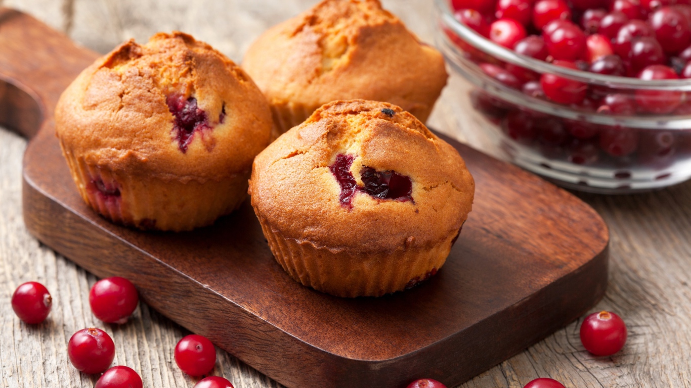 Три кекса с клюквой на разделочной доске