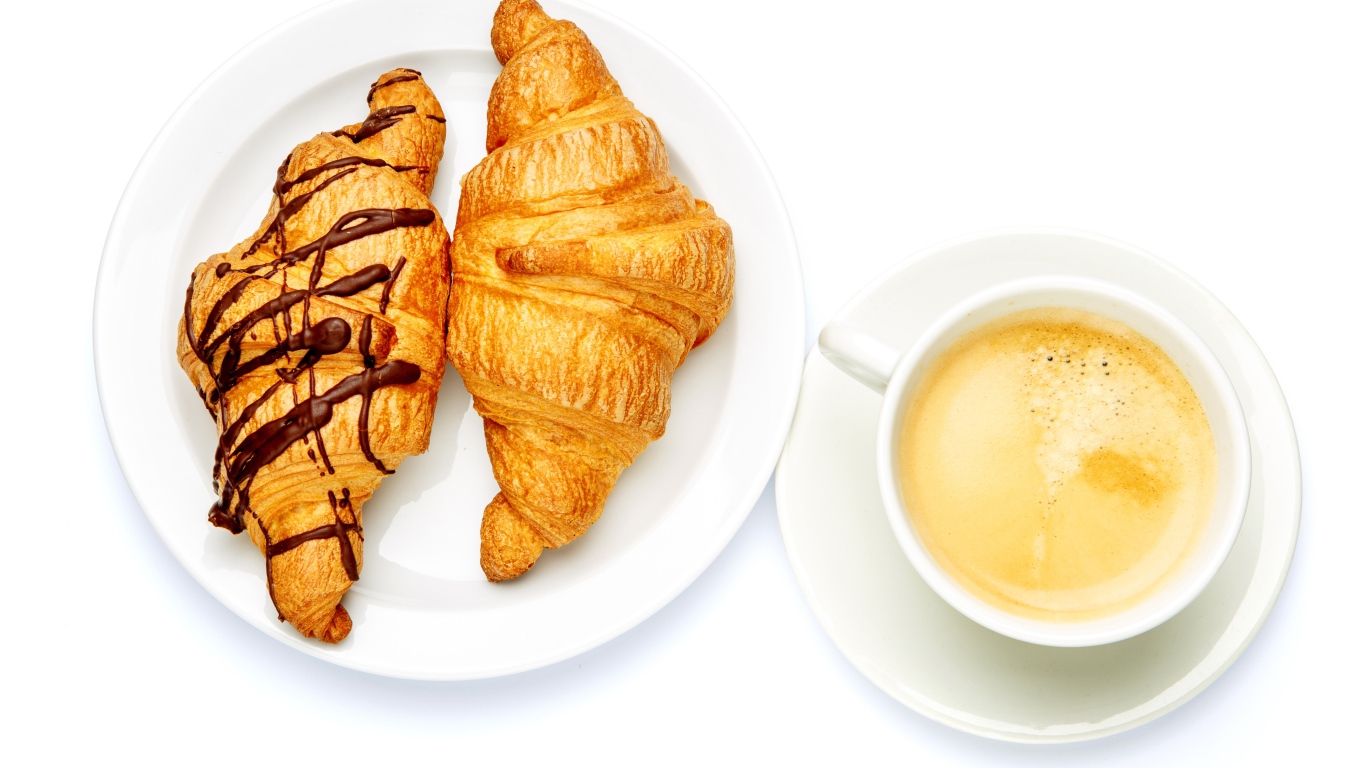 Два круассана с чашкой кофе на белом фоне