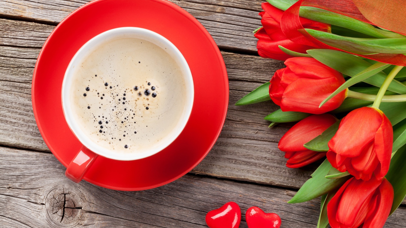 Чашка кофе с красными тюльпанами на деревянном столе 