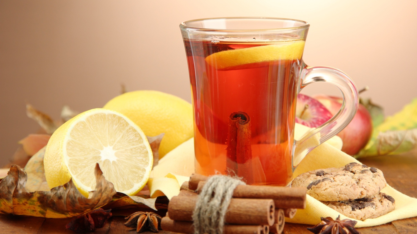 Чашка чая с лимоном и корицей на столе с лимонами