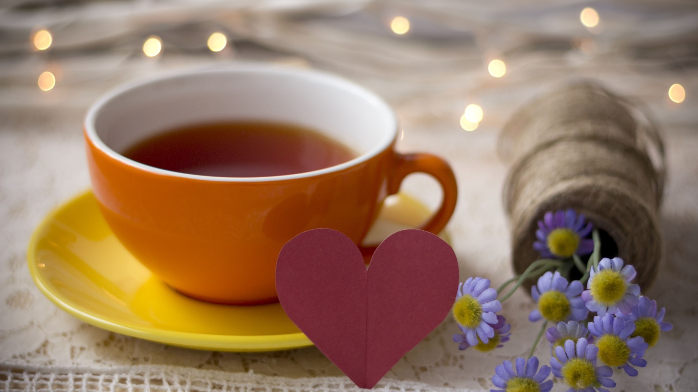 Большая чашка чая на столе с розовым бумажным сердцем и цветами