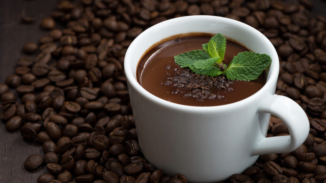 Белая чашка горячего шоколада стоит на кофейных зернах