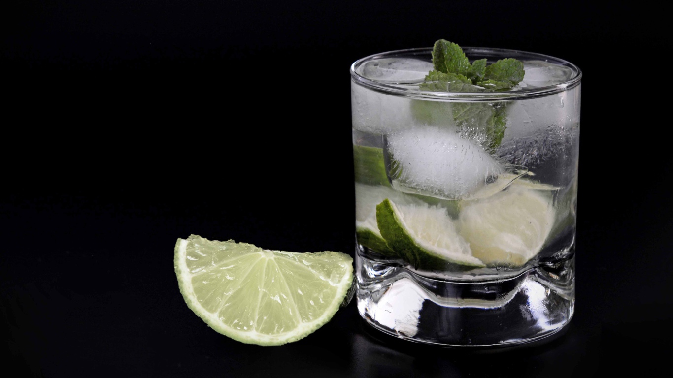 Коктейль кайпиринья на черном фоне с кусочком лайма