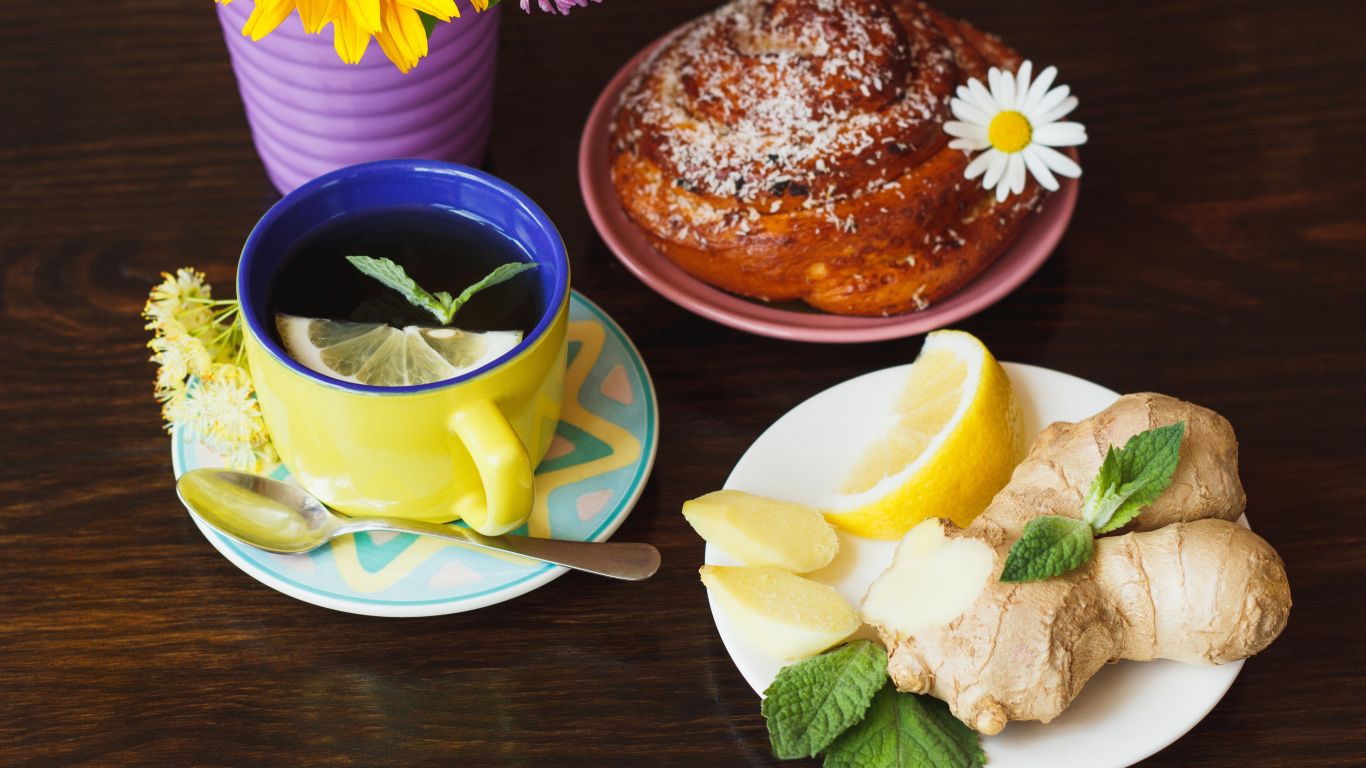 Липовый чай с имбирем и лимоном на столе со свежей булочкой