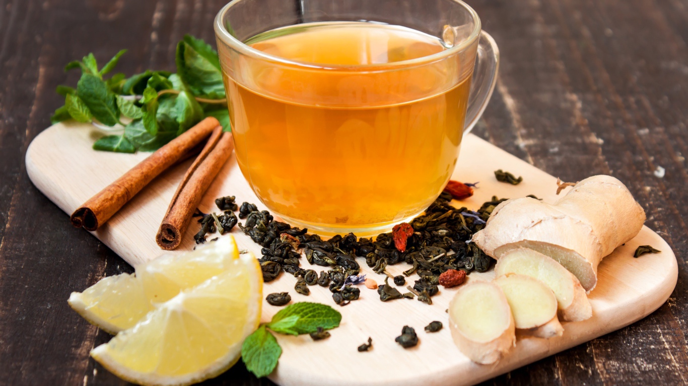 Чай с имбирем, лимоном, корицей и мятой на разделочной доске