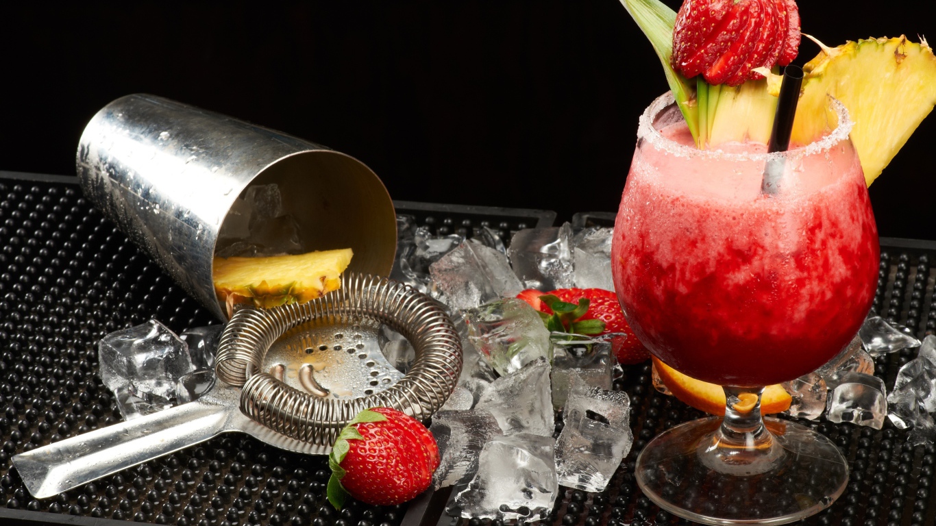 Тропический коктейль в бокале на столе со льдом