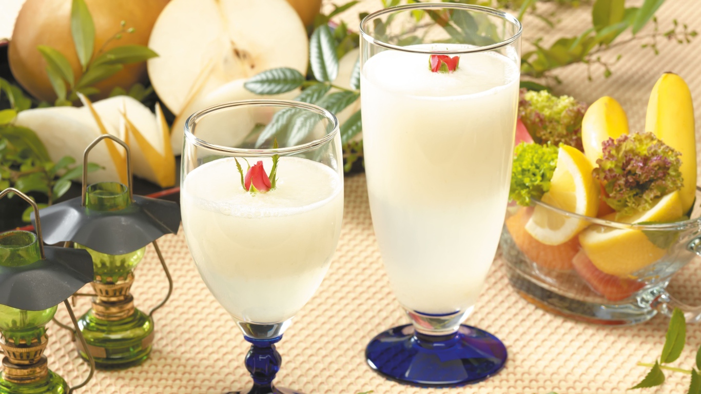 Два бокала сока на столе с фруктами