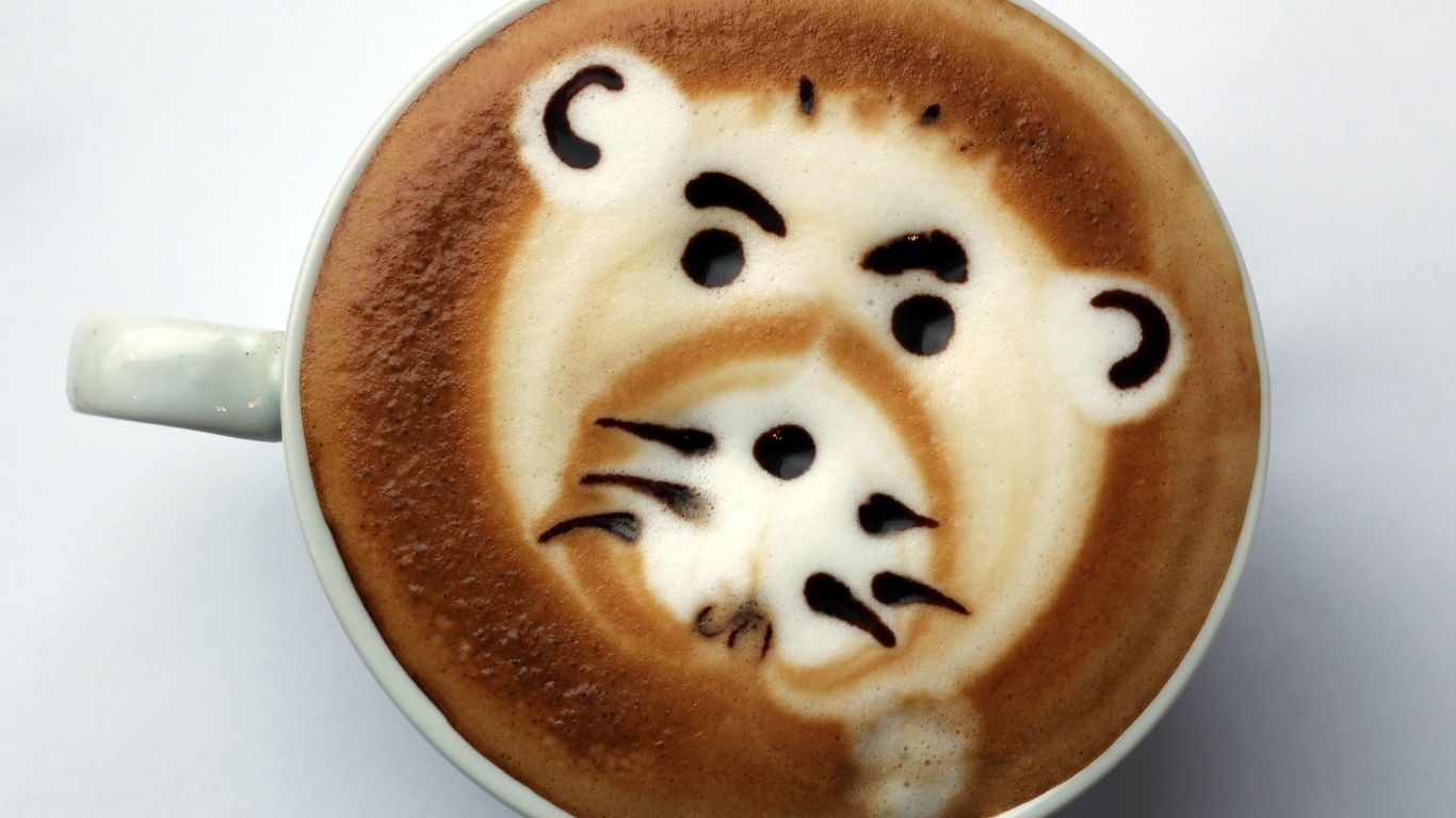 Белая чашка кофе с забавным рисунком на пене