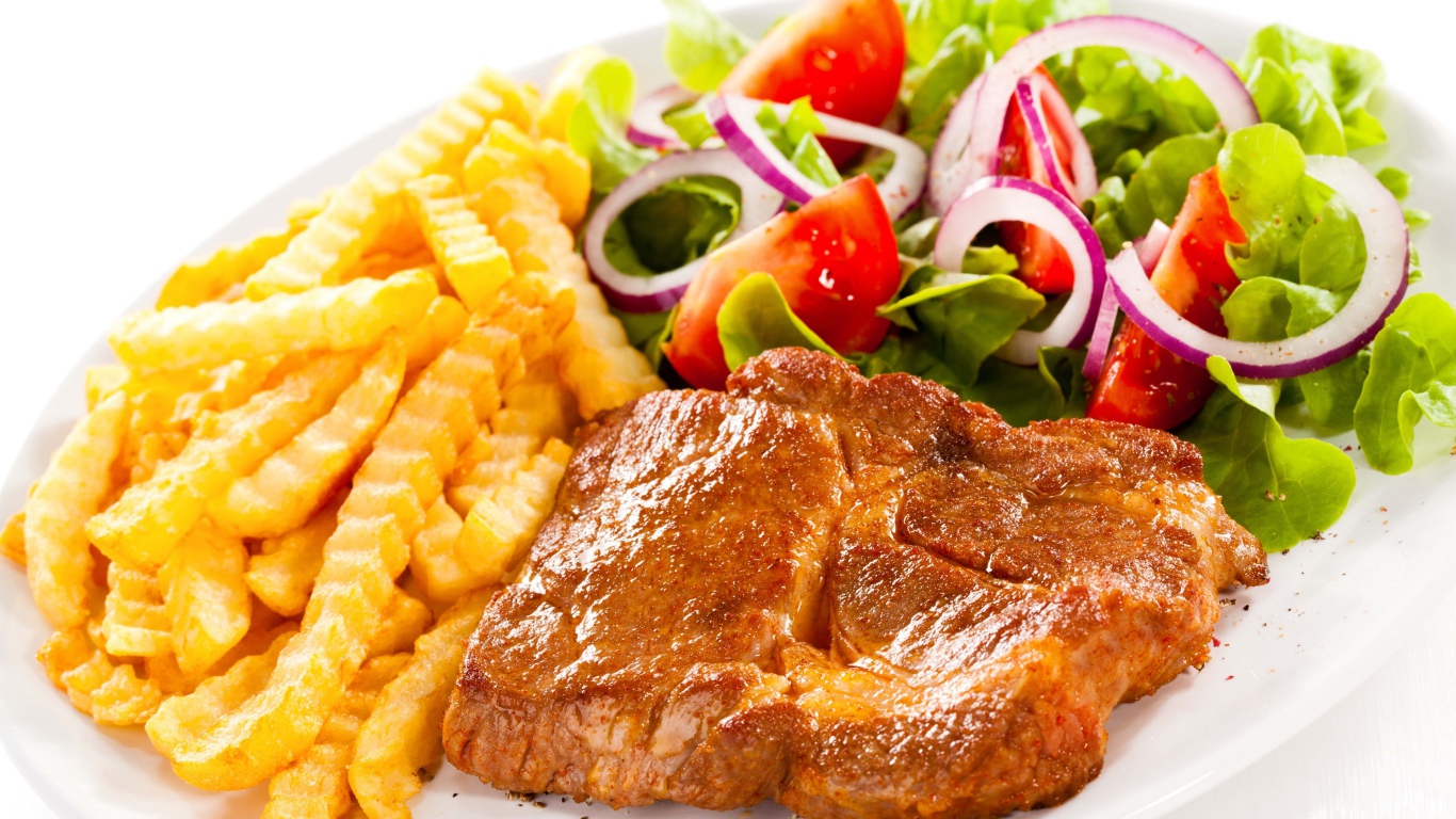 Appetizing chop on a plate with french fries and salad