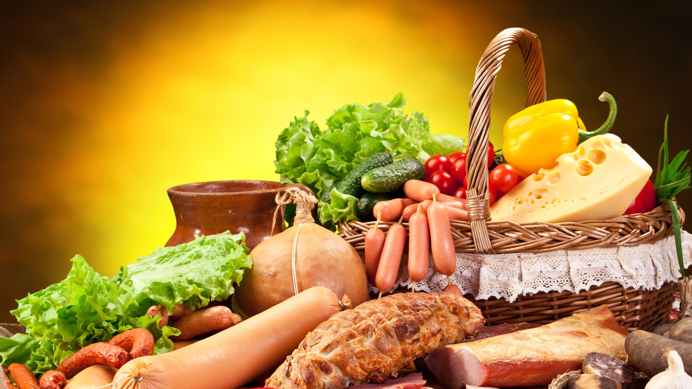 Аппетитные мясные продукты на столе с корзиной овощей