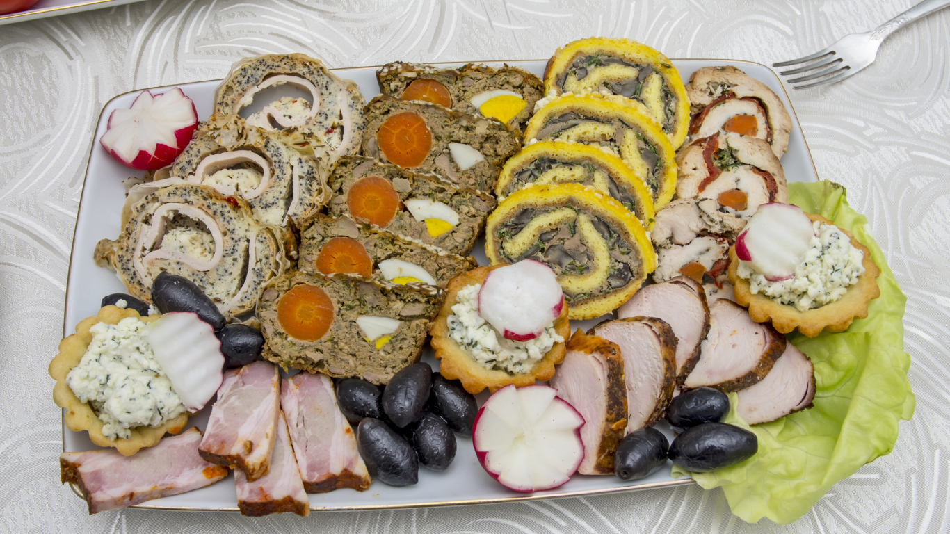 Мясные рулеты на тарелке с оливками 