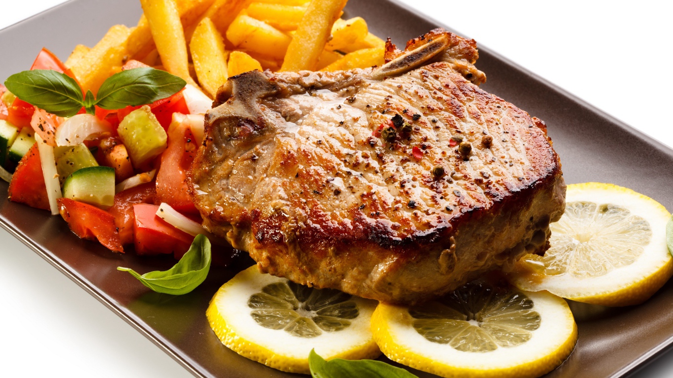 Мясо с картофелем  фри, салатом и кусочками лимона