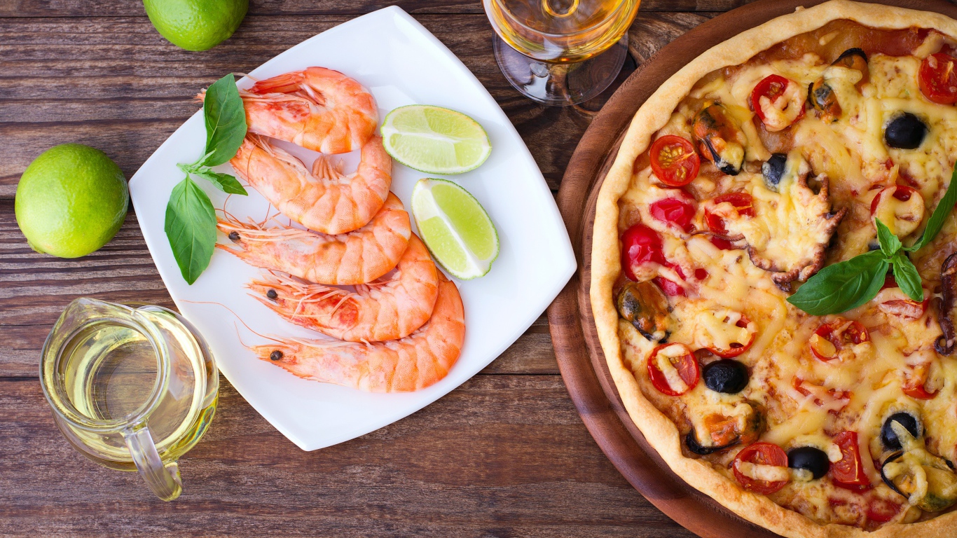 Аппетитная пицца на столе с креветками и кусочками лайма 
