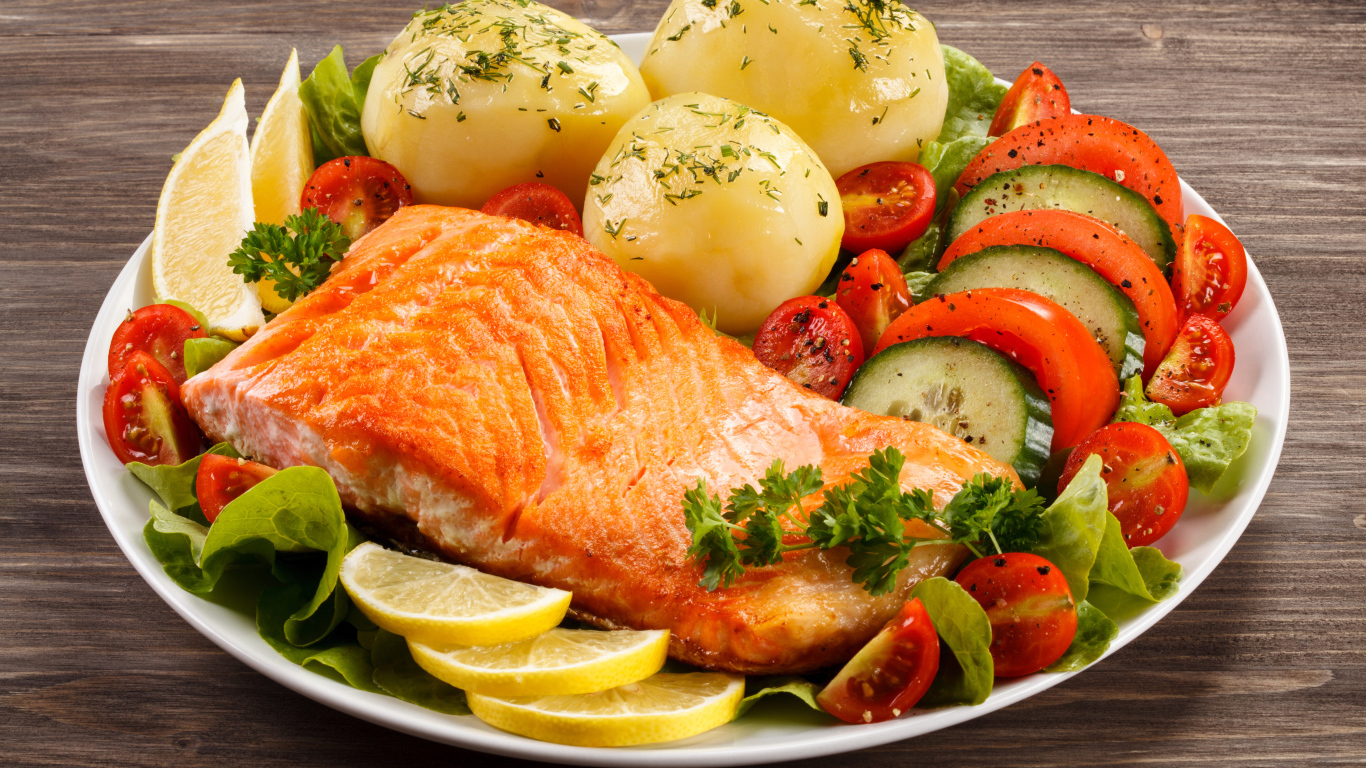 Кусок жареной рыбы на тарелке с овощами