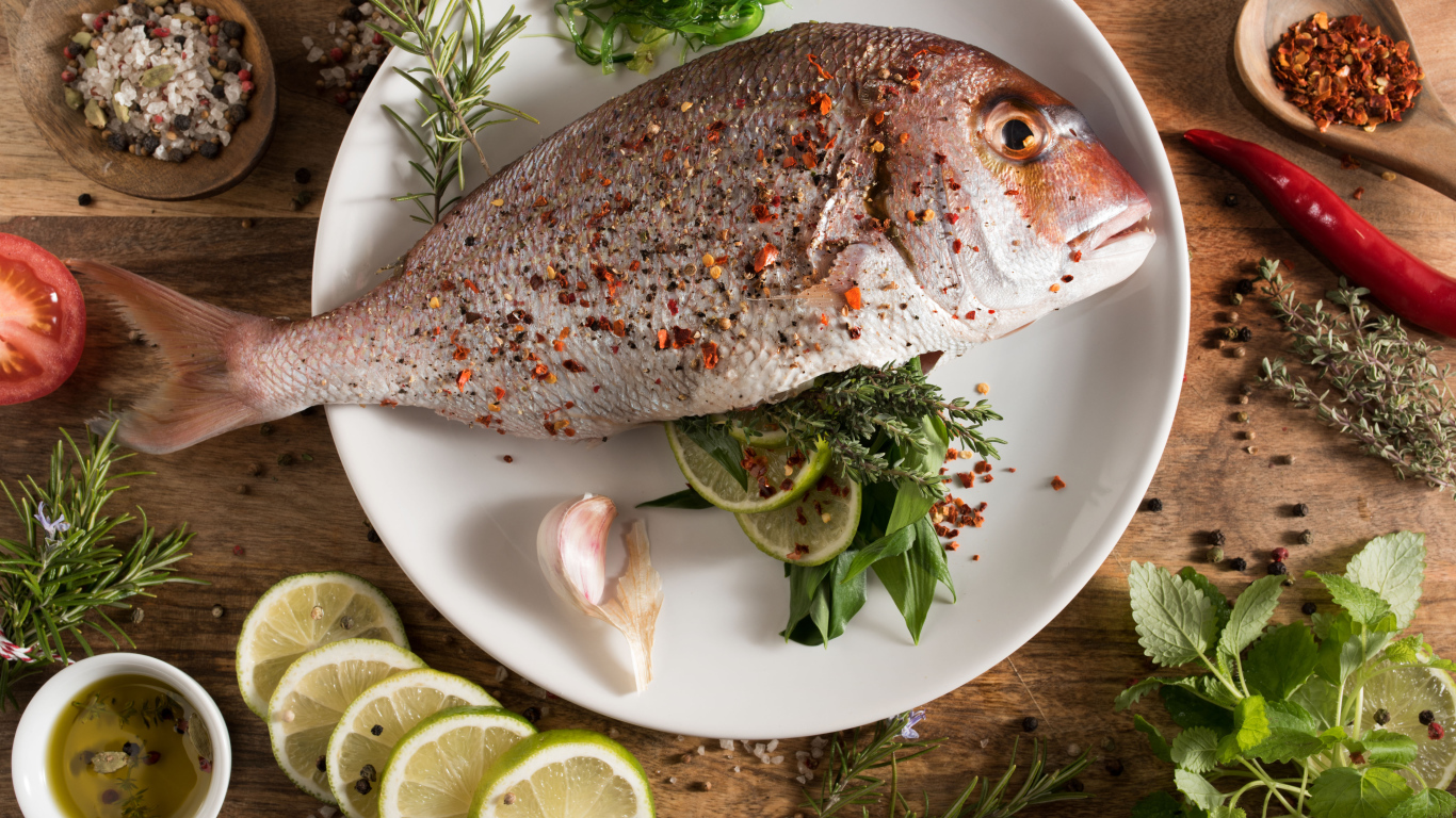 Рыба на тарелке со специями и лаймом