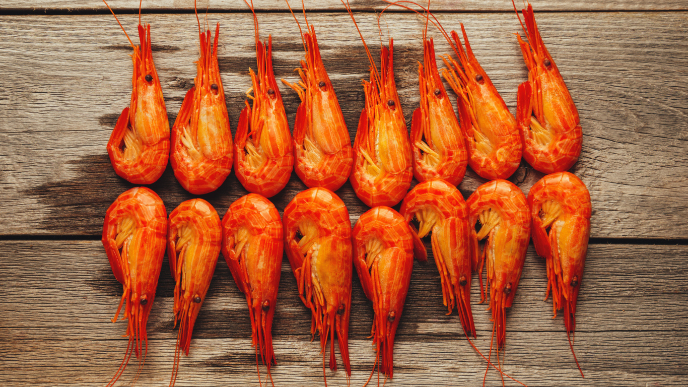 Красные вареные креветки на деревянном столе
